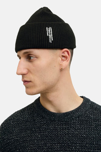 Zwarte muts van ACCESSORIES BY JACK & JONES, met ribtextuur, gedragen door een model in een grijs gemêleerde trui.
