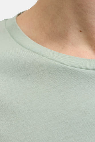 Groen T-shirt met korte mouwen van JJREBEL, close-up van de kraag en schouder.
