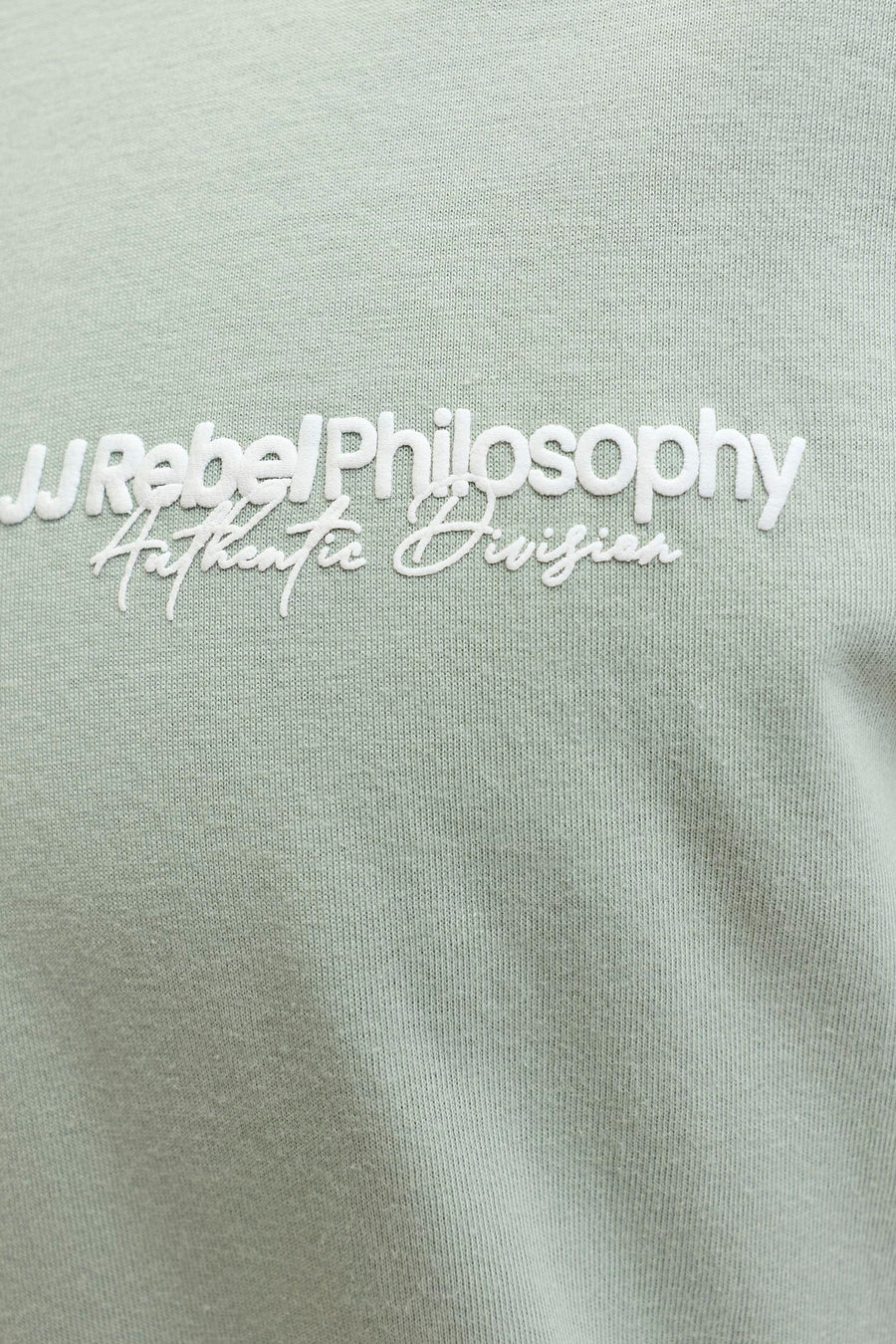Groen T-shirt met korte mouwen van JJREBEL met witte opschrift 'Rebel Philosophy Authentic Division'.
