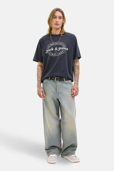 Zwart T-shirt met korte mouwen van ORIGINALS BY JACK & JONES, met witte opdruk, gedragen met wijde jeans en witte sneakers.