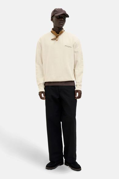 Ecru sweater van ORIGINALS BY JACK & JONES, met bruine halsdoek en zwarte pantalon.