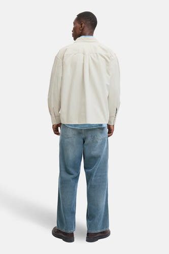 Beige hemd van PREMIUM BLUE by JACK & JONES, los model, gedragen met blauwe jeans en bruine schoenen, rugaanzicht.