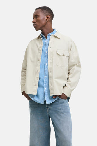Beige overhemd van PREMIUM BLUE by JACK & JONES, gedragen over een blauw denim overhemd met jeans.