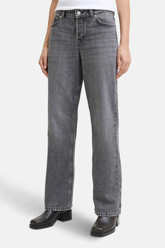 Jean droit gris de JJXX, avec fermeture à boutons et porté avec des bottes en cuir noir.