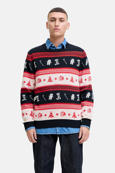 Multikleurige trui met ronde hals van ORIGINALS BY JACK & JONES, met kerstmotieven zoals kerstbomen en gingerbreadmannetjes, gedragen over een denim overhemd met donkere jeans.
