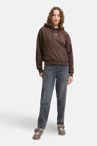 Pull-over marron avec capuche JJXX, porté avec des jeans gris et des baskets marrons.
