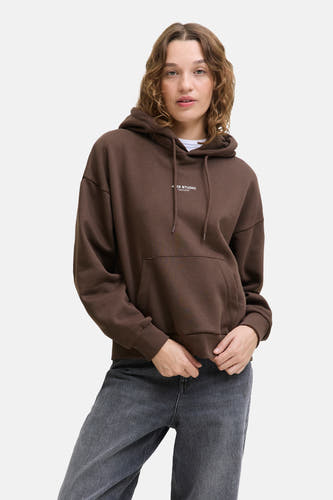 Pull marron avec capuche JJXX, manches longues et poche avant, associé à des jeans gris.