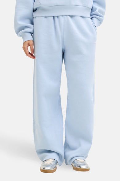 Blauw joggingbroek van JJXX, met wijde pijpen en zilverkleurige sneakers met bruine zolen.
