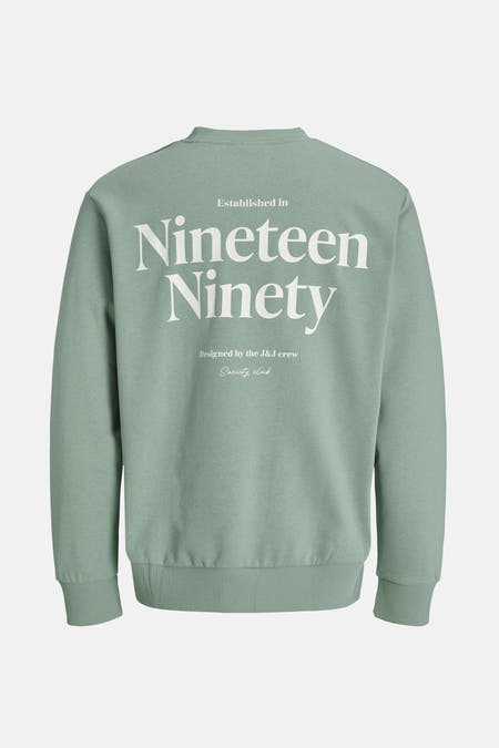 Groene sweater van ORIGINALS by JACK & JONES, met witte 'Nineteen Ninety' tekst op de achterkant.
