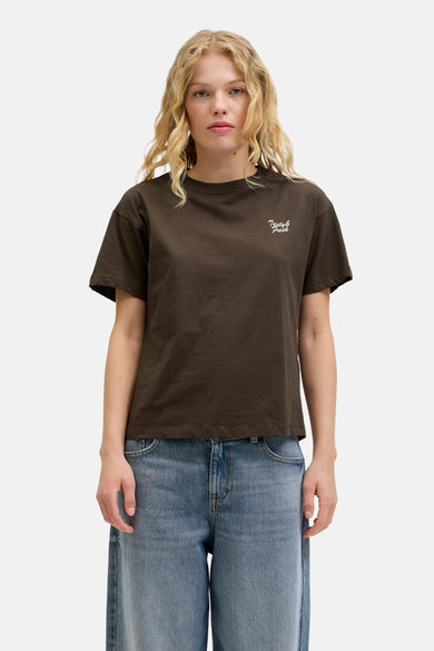 Bruin T-shirt met korte mouwen van JJXX, met een witte 'Tasty & Fresh' tekstprint, gecombineerd met wijde jeans.
