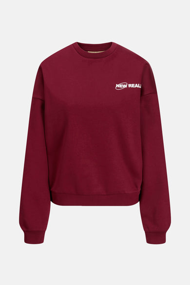 Gilet rouge à col rond de JJXX, avec une impression de texte "New Real" blanche sur la poitrine.