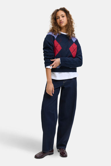 T-shirt bleu avec col rond de JJXX, à carreaux et associé à un chemisier blanc et des jeans foncés.
