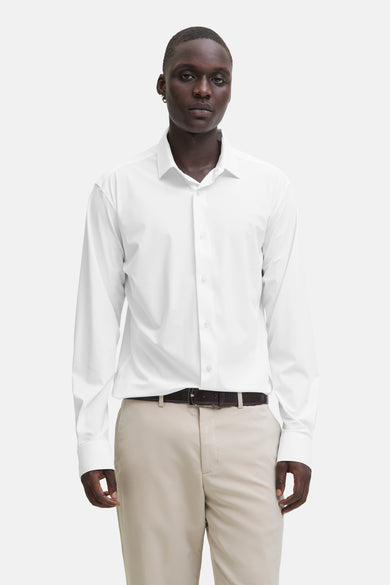 Wit hemd met lange mouwen van PREMIUM by JACK & JONES, gedragen met een bruine riem en kaki broek.
