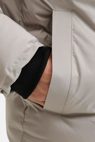 Ecrukleurige korte jas van CORE BY JACK & JONES, met hand in zak en zwarte mouwboord zichtbaar.