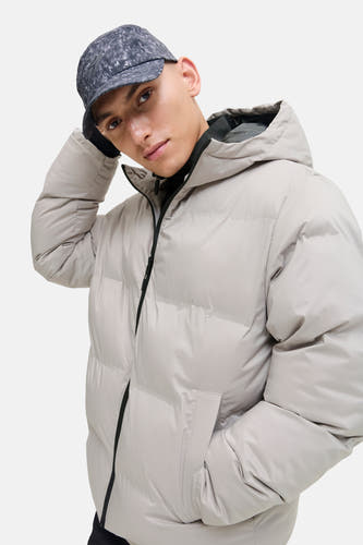 Ecrukleurige korte jas van CORE BY JACK & JONES, met capuchon en een man met een pet.
