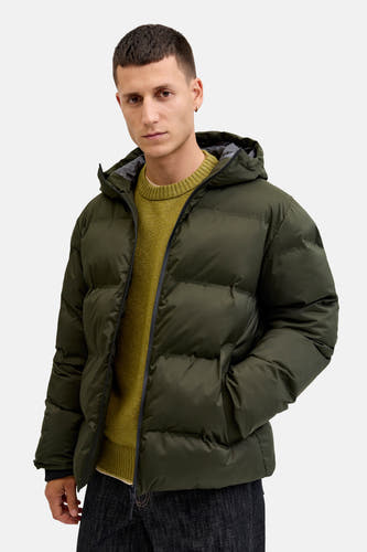 Groene korte jas van CORE BY JACK & JONES, met capuchon en een man met een mosterdgele trui.
