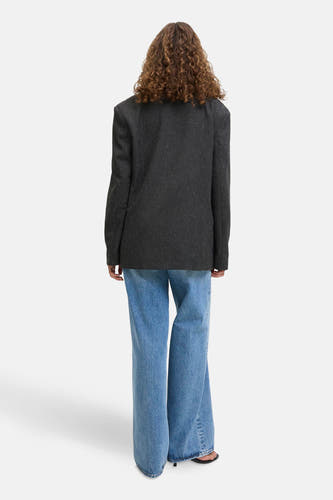 Grijze blazer van JJXX, met lange mouwen en gedragen over wijde, lichtblauwe jeans.
