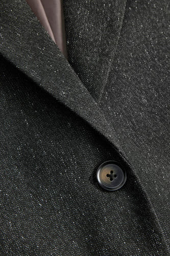 Grijze blazer van JJXX, met subtiele spikkels en een donkerbruine knoop.