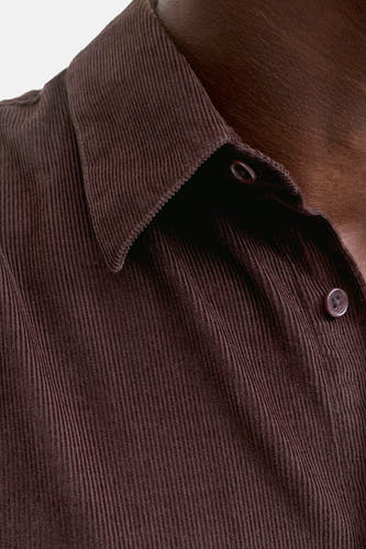 Bruin corduroy overhemd met lange mouwen van PREMIUM BLUE by JACK & JONES, close-up met knopen en kraag.
