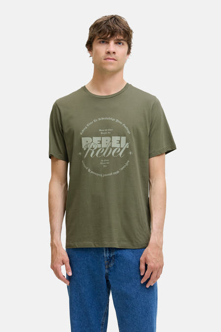 Groen T-shirt met korte mouwen van JJREBEL, met ronde hals en tekstprint, gecombineerd met een blauwe jeans.
