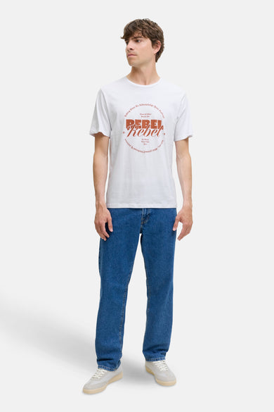 Wit T-shirt met korte mouwen van JJREBEL, met een vintage geïnspireerde print op de voorkant, gedragen met jeans en sneakers.
