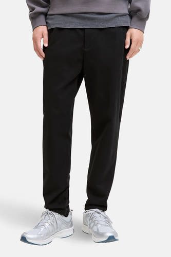 Zwarte broek van JACK & JONES JEANS INTELLIGENCE, met grijze sweater en zilveren sneakers.