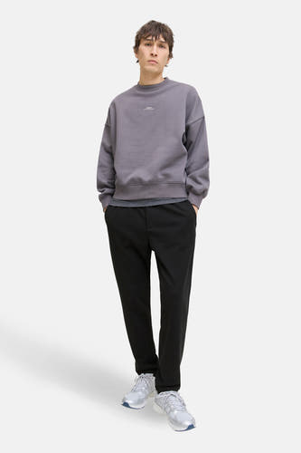 Zwarte broek van JACK & JONES JEANS INTELLIGENCE, gestyled met een grijze sweater en witte sneakers.
