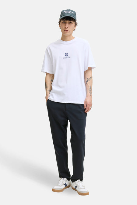 Blauwe broek van JACK & JONES JEANS INTELLIGENCE, gecombineerd met een wit T-shirt en een pet.