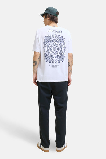 Blauwe broek van JACK & JONES JEANS INTELLIGENCE, gezien van achteren, gecombineerd met een wit T-shirt en een groene pet.