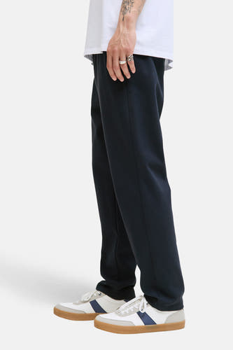 Blauwe broek van JACK & JONES JEANS INTELLIGENCE, met witte schoenen en zilveren ringen.