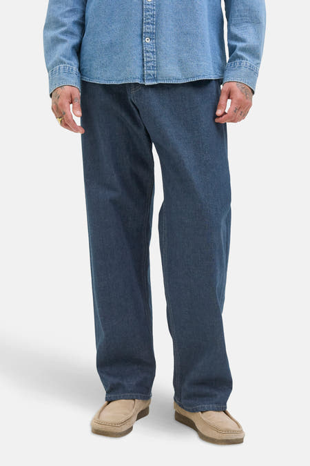 Jean décontracté de denim bleu foncé de JACK & JONES JEANS INTELLIGENCE, avec des mocassins clairs et une chemise en jean.