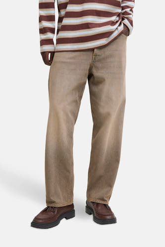 Jean large bleu de JACK & JONES JEANS INTELLIGENCE, porté avec un chemisier rayé et des chaussures en cuir à semelle crantée.