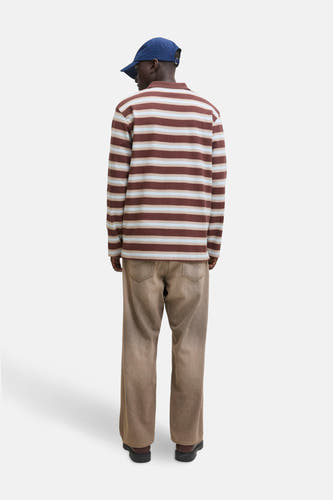 Jean brut large de JACK & JONES JEANS INTELLIGENCE, associé à une polo rayée et un casque bleu.