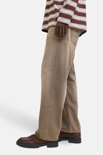 Jean boyfriend bleu de JACK & JONES JEANS INTELLIGENCE, associé à des chaussures en cuir marron foncé et une chemise rayée.