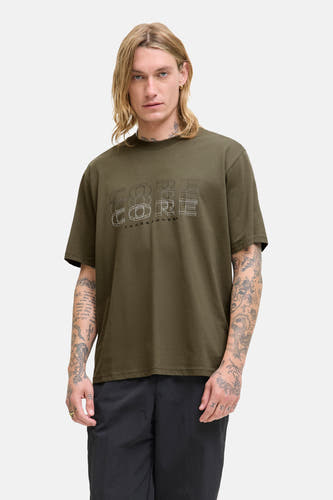 T-shirt vert de mantes courtes man CORE par JACK & J, avec un une im im sur la devantière portéé des pantalons noirs.
