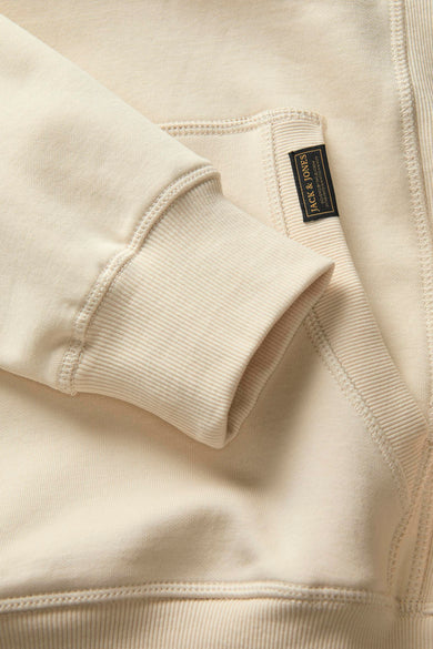 Beige sweater van PREMIUM BLUE by JACK & JONES, met ribgebreide mouwboorden en een label op de zak.