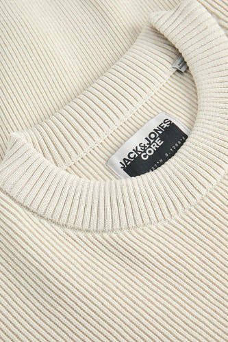 Beige trui met ronde hals van CORE BY JACK & JONES, close-up op de kraag en het label.