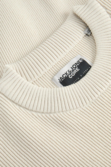 Beige trui met ronde hals van CORE BY JACK & JONES, close-up op de kraag en het label.