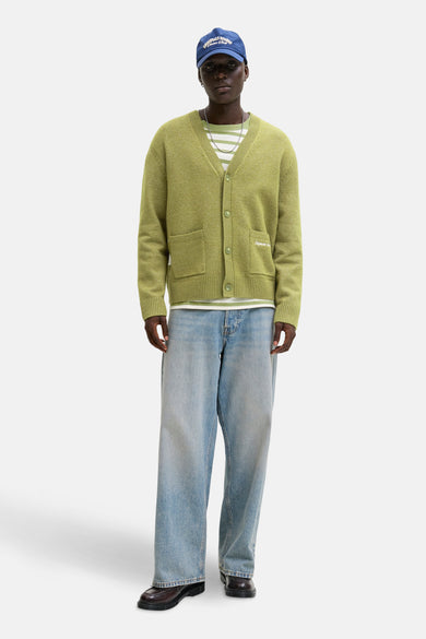 Groene gilet van ORIGINALS BY JACK & JONES, gedragen over een gestreept shirt met blauwe pet en wijde jeans.
