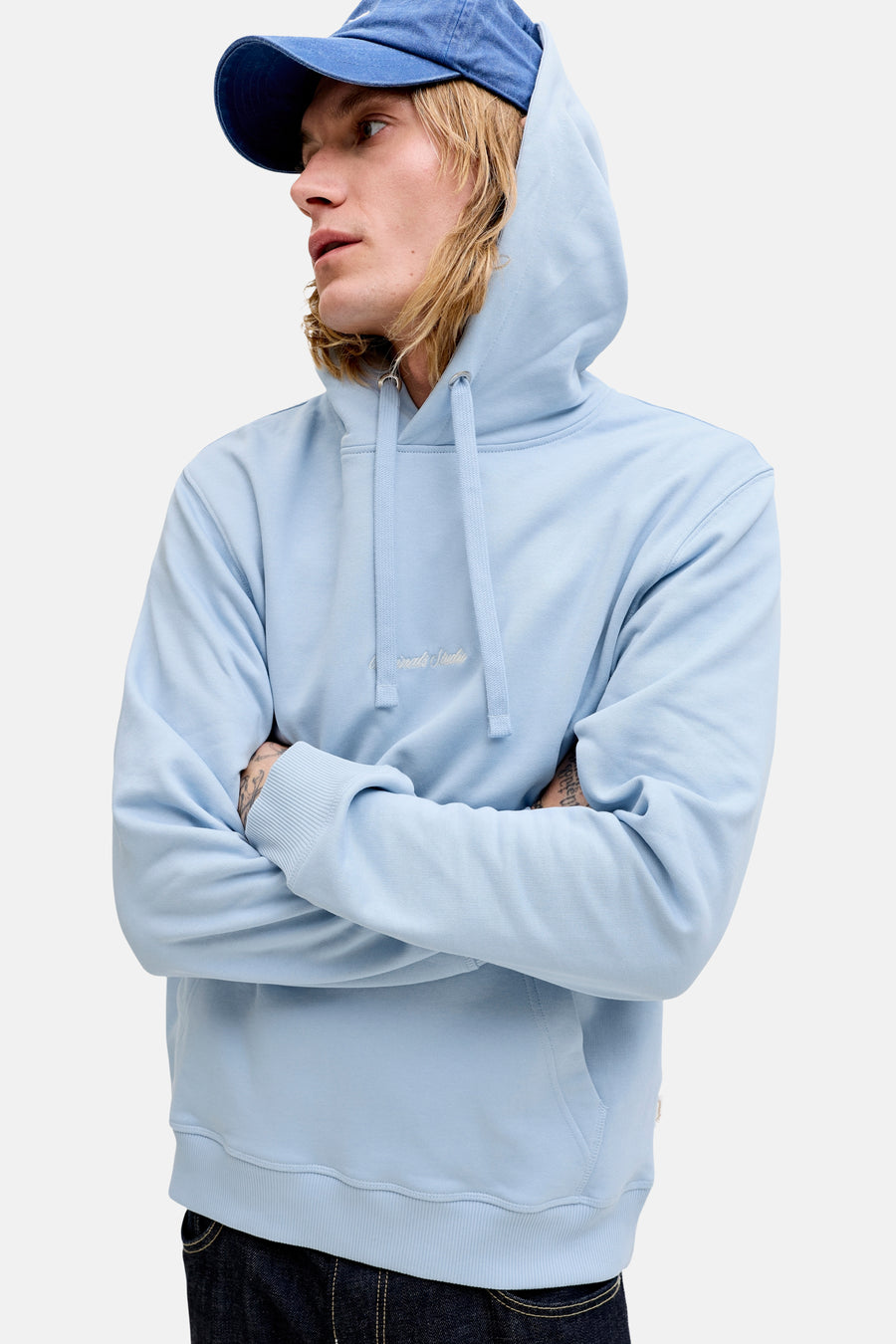 Sweat à capuche bleu de ORIGINALS BY JACK & JONES avec cordon de serrage et broderie subtile sur la poitrine, porté par un homme.