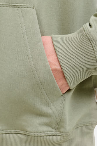 Sweat à capuche vert d'ORIGINALS BY JACK & JONES, gros plan sur la poche et la manche côtelée.