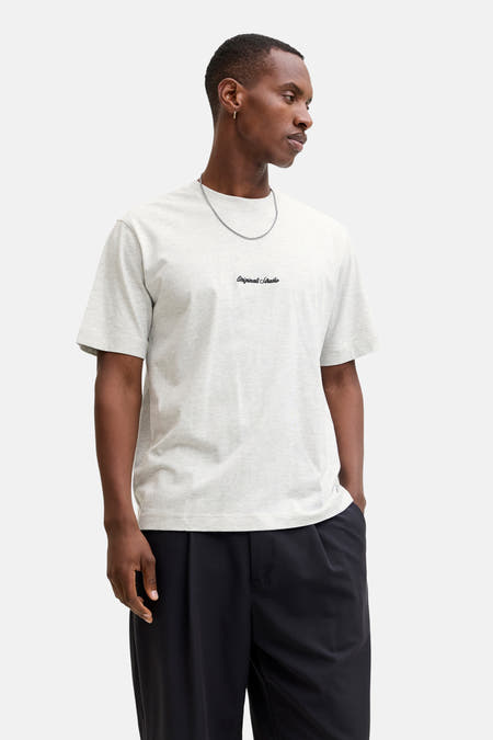 Grijs T-shirt met korte mouwen van Originals by Jack & Jones, met een klein logo en gedragen met een zilveren ketting.
