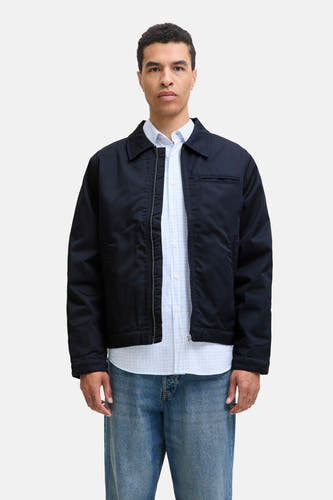 Blauwe korte jas van ORIGINALS BY JACK & JONES, gedragen over een lichtblauw overhemd met ruitpatroon en jeans.