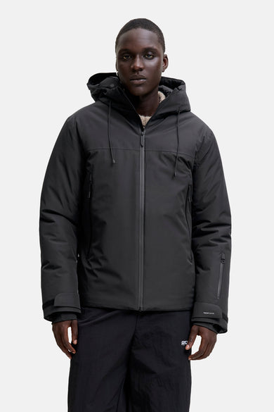 Zwarte, korte jas van CORE BY JACK & JONES, met capuchon en zwarte broek.