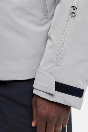 Korte grijze jas van CORE BY JACK & JONES, met een mouwzak met ritssluiting en klittenbandsluiting bij de manchet.
