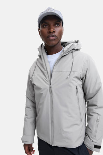 Korte grijze jas van CORE BY JACK & JONES, met capuchon en zichtbare ritsen op de voorzijde.
