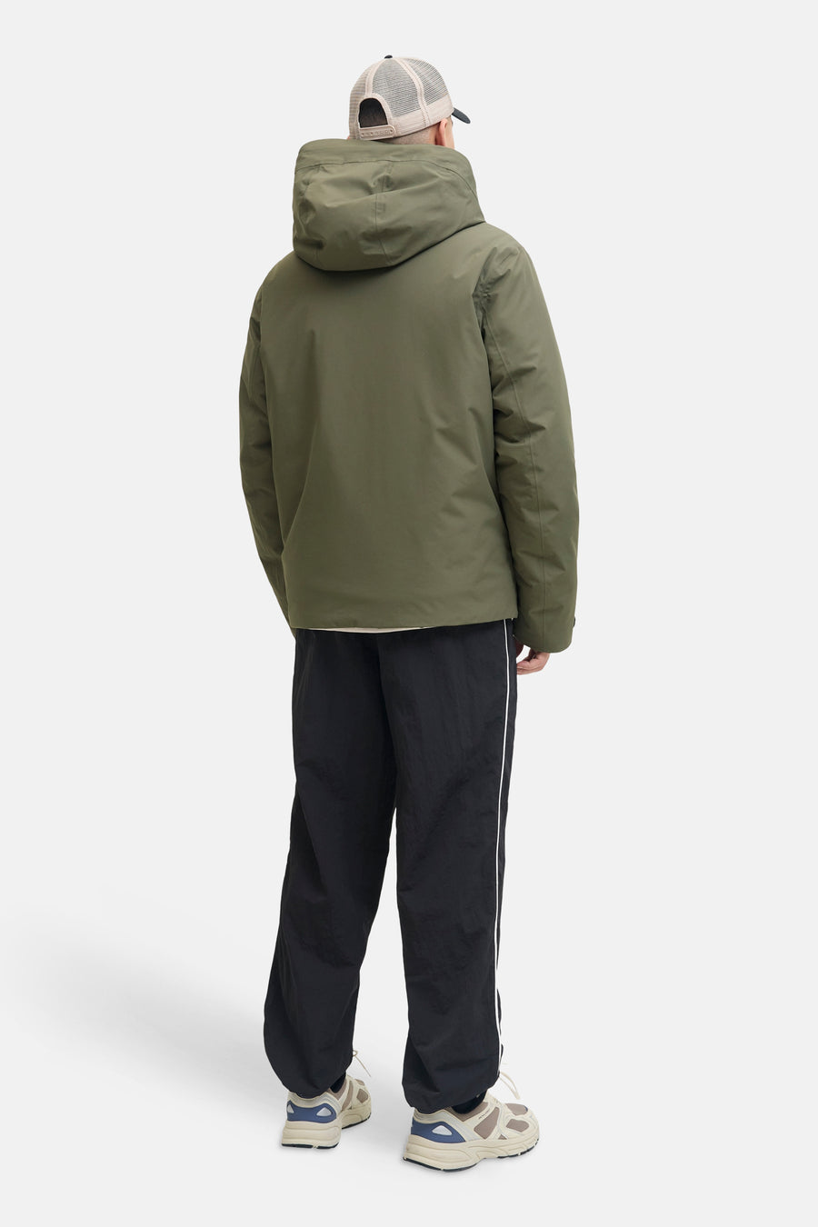 Veste courte verte de CORE BY JACK & JONES, portée de dos avec capuche, casquette de camionneur, pantalon noir à rayures et baskets.