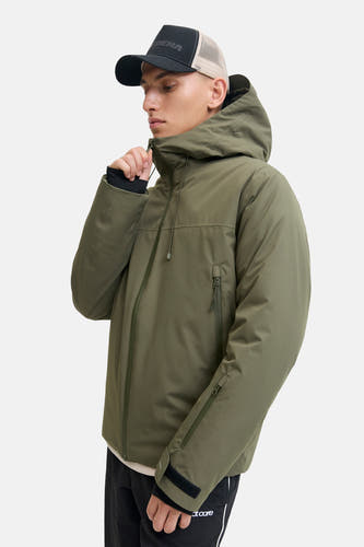 Veste courte verte de CORE BY JACK & JONES avec capuche, fermetures éclair et fermetures velcro, portée par un mannequin avec casquette.