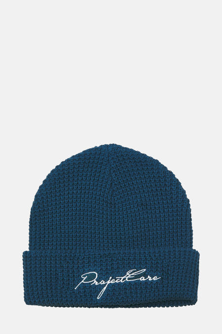 Blauwe muts van ACCESSORIES BY JACK & JONES met geborduurde tekst op de omslag.
