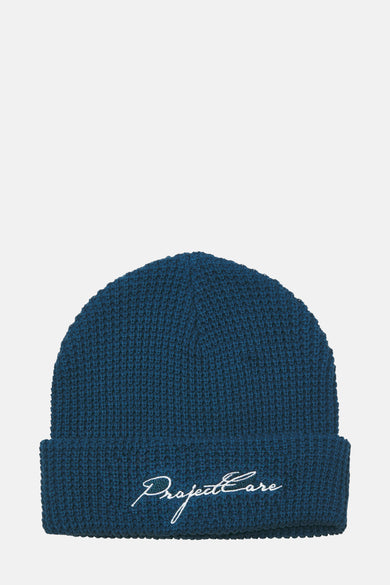 Blauwe muts van ACCESSORIES BY JACK & JONES met geborduurde tekst op de omslag.
